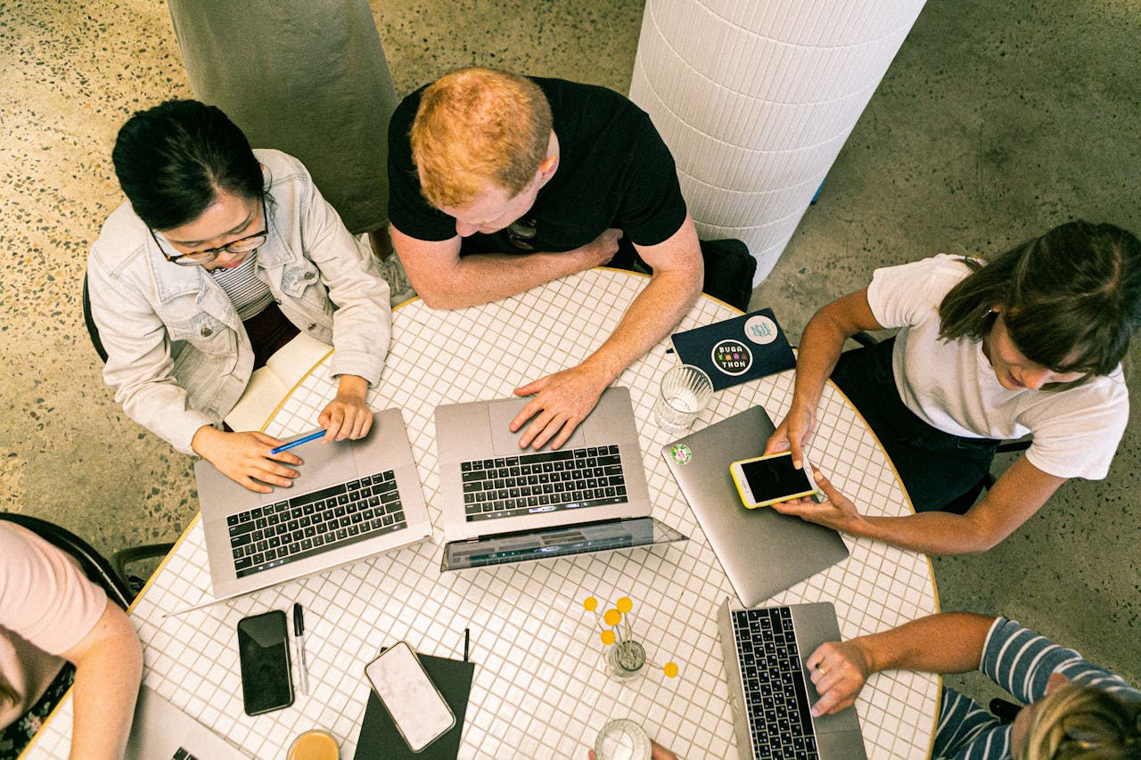 gallery-4 Top view of diverse team collaboratively working in a modern office setting.